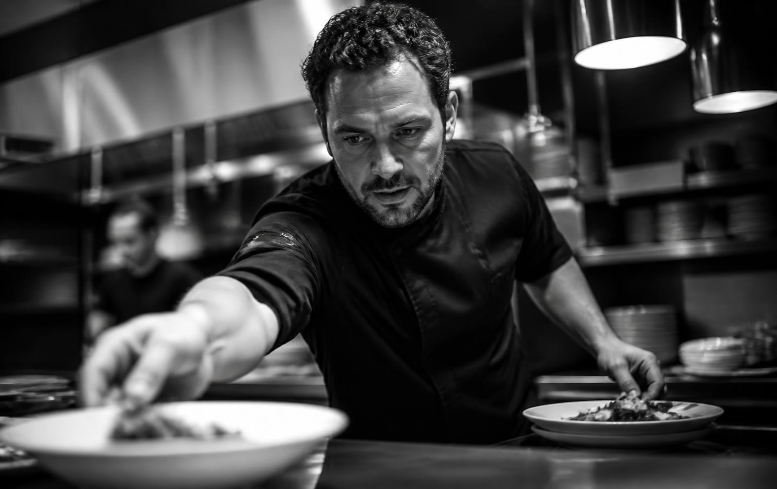 Chef reaching across the pass during service